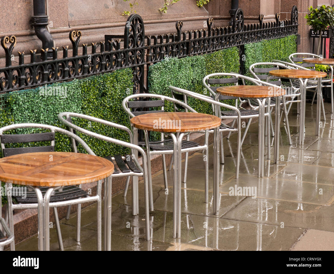 Outside cafe tables in the rain on a street in Edinburgh, Scotland. Stock Photo