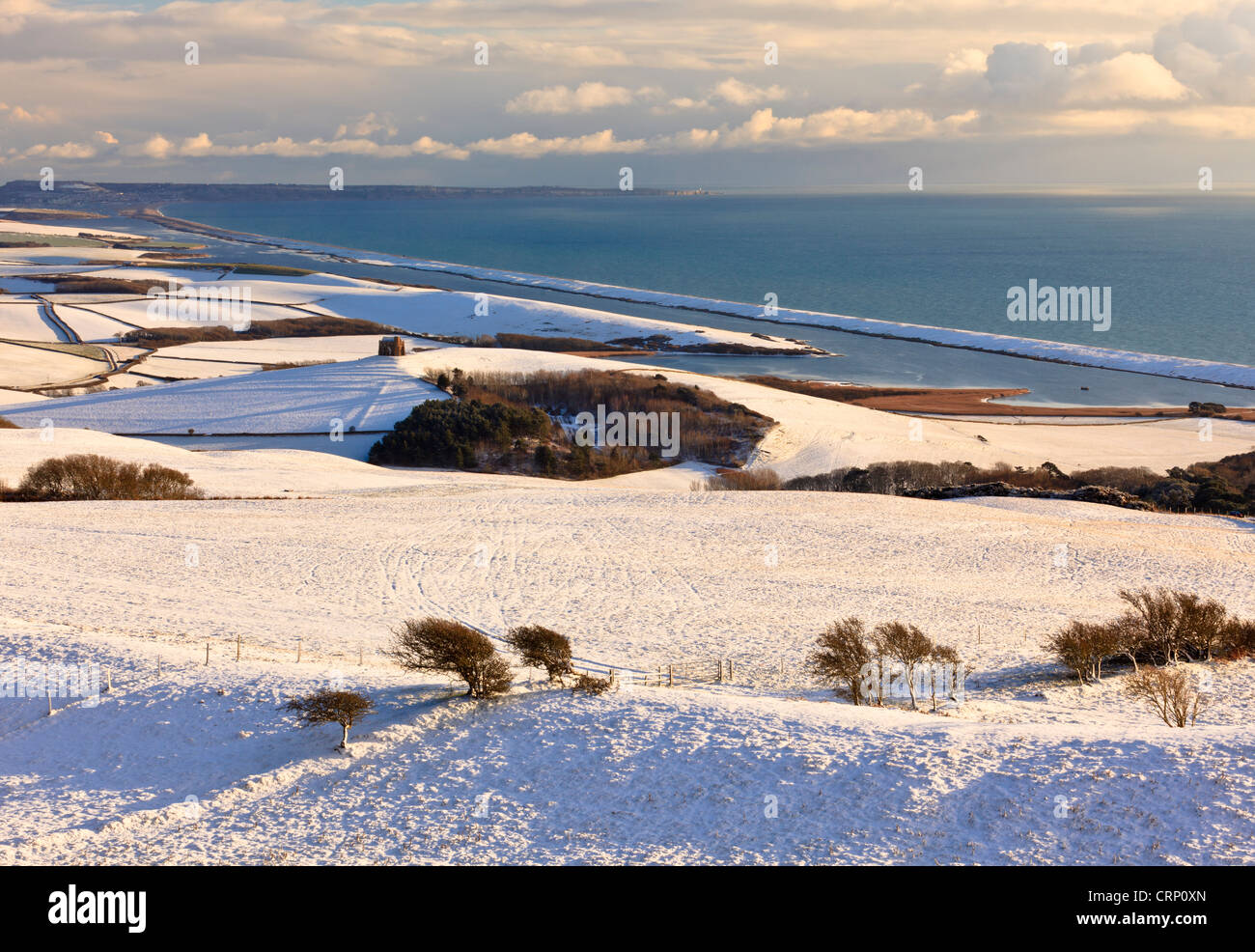 View of snow-covered hills around Abbotsbury, with St Catherine's Chapel, the Fleet and Chesil Bank in the background. Stock Photo