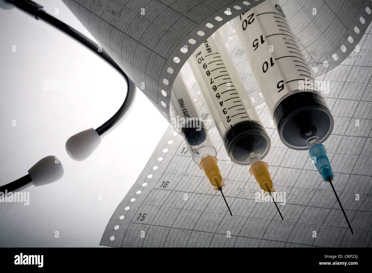A stethoscope an injection lying on an electrocardiogram readout Stock ...