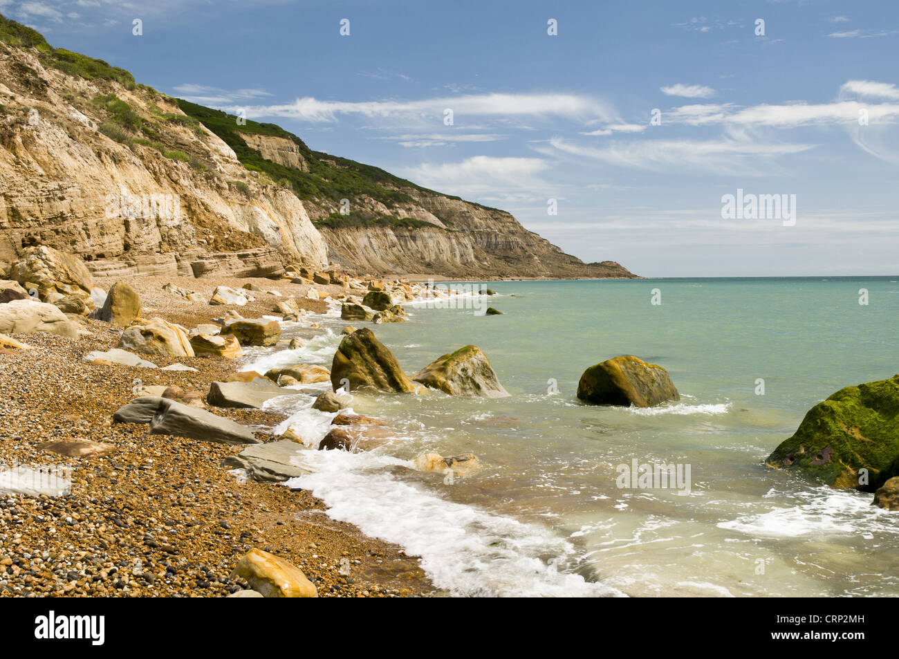 Rocks on beach and in sea under sandstone cliffs, Fairlight Cove