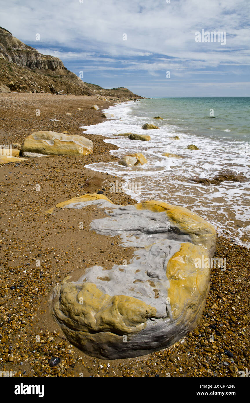 Rocks on beach and in sea under sandstone cliffs, Fairlight Cove, Covehurst Bay, near Hastings