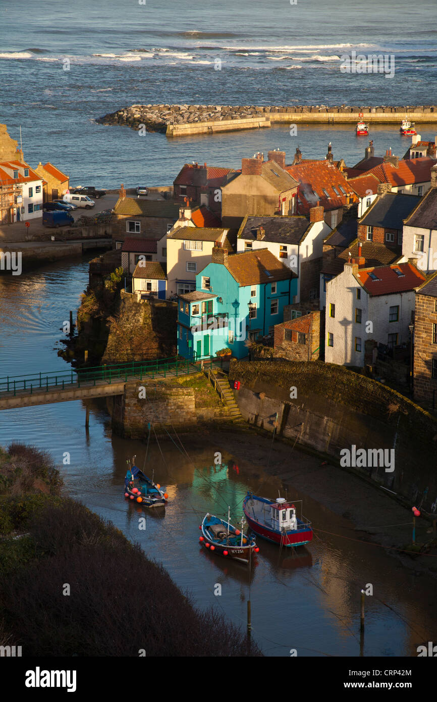 Fishing boats in the sheltered harbour at Staithes at dusk. Stock Photo