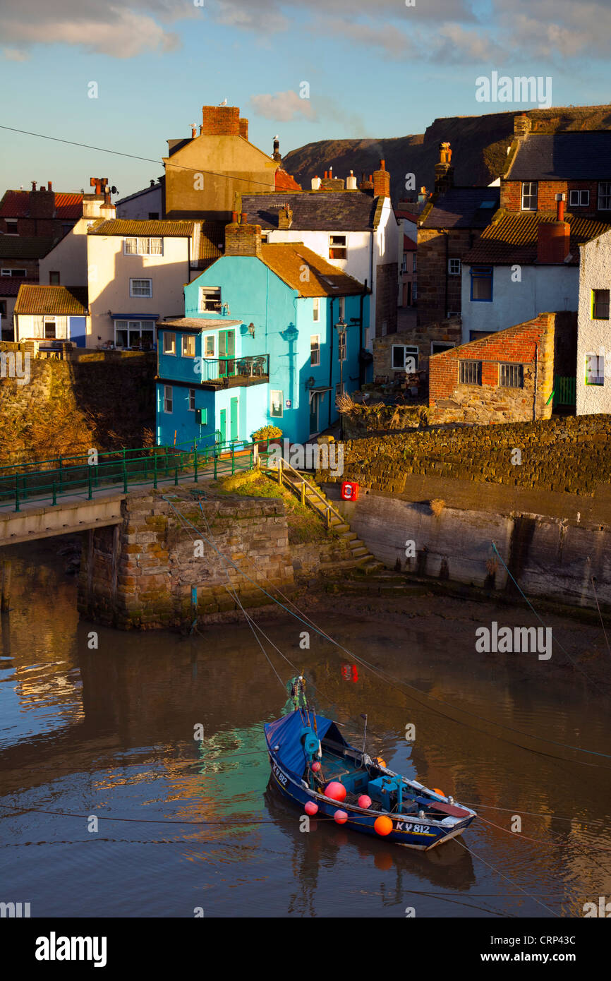 A fishing boat in the sheltered harbour at Staithes at dusk. Stock Photo