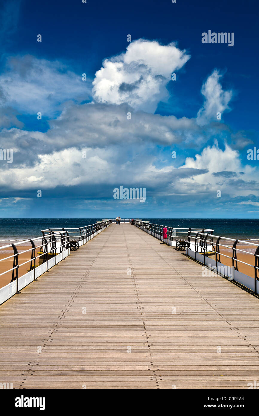 A couple walking along Saltburn's Victorian pier, the most northerly surviving British pier and the only remaining pleasure pier Stock Photo