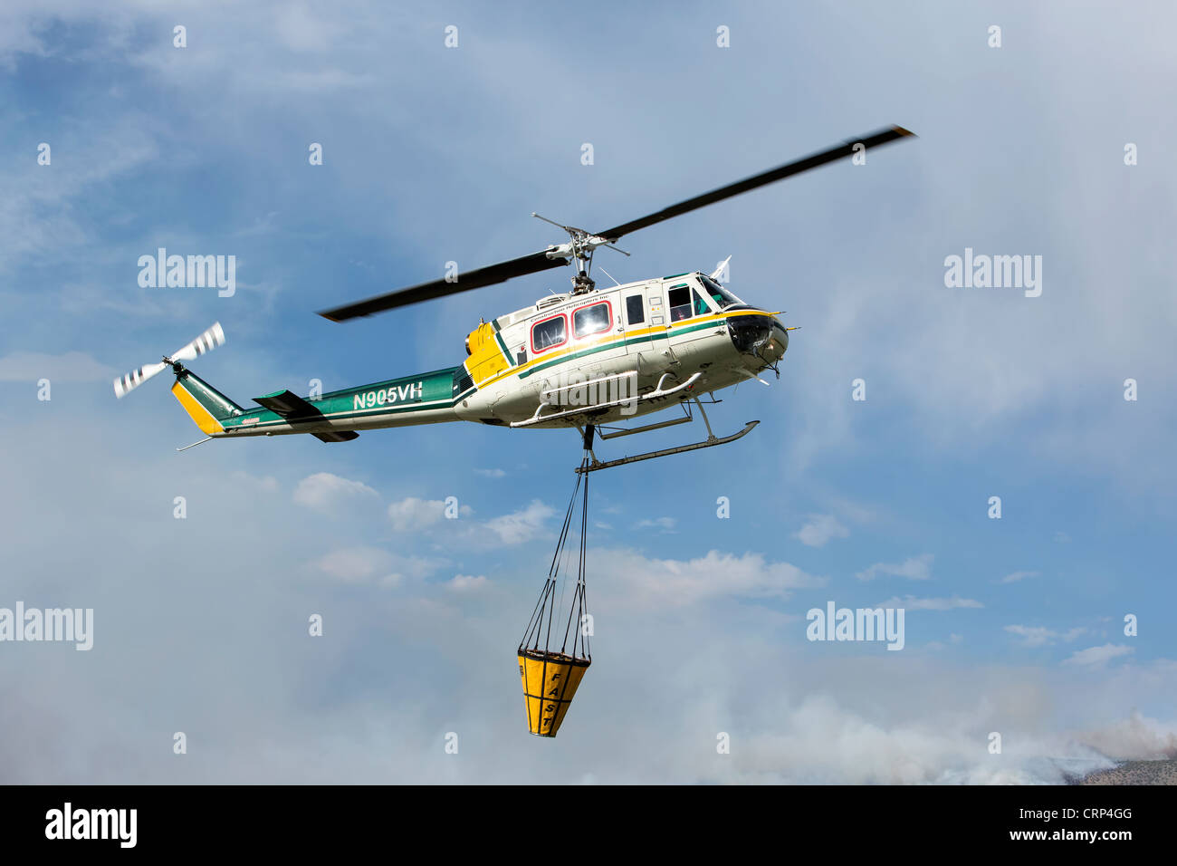 Helicopter aerial forest fighting aircraft filling bucket with water
