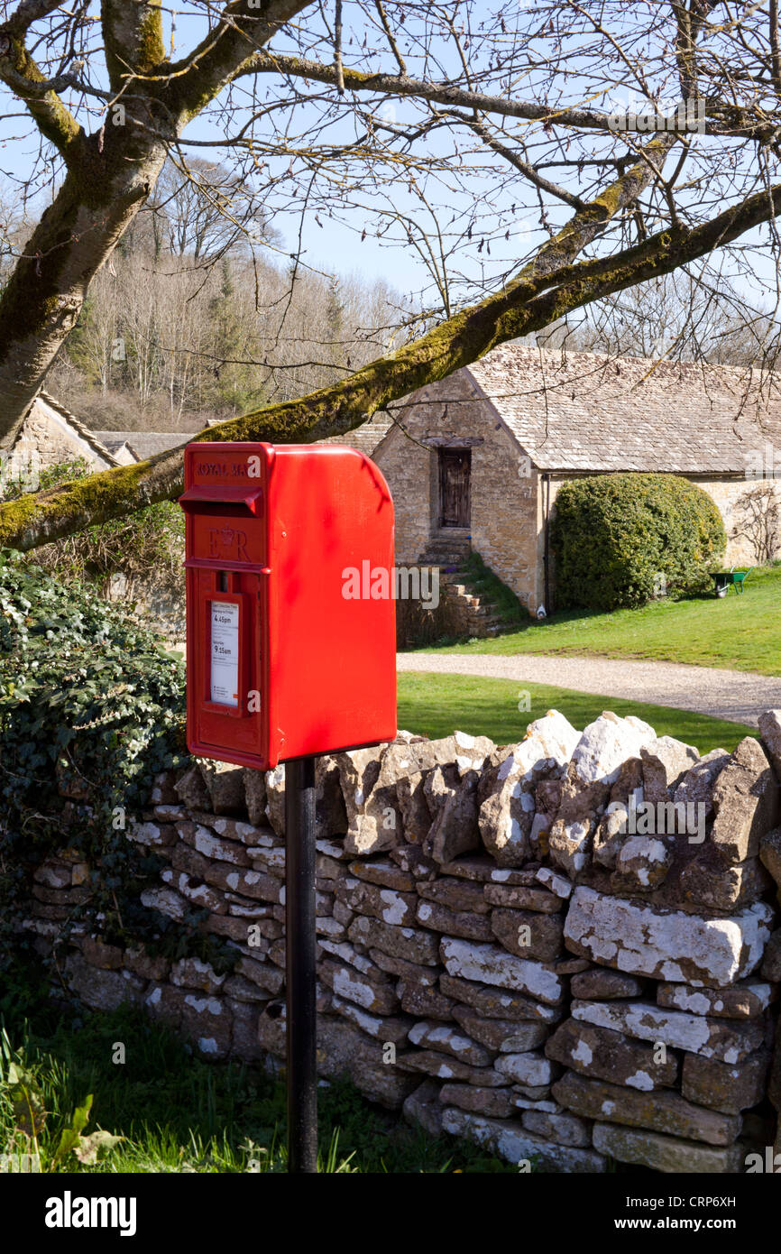 Traditional red British post box in the Cotswold village of