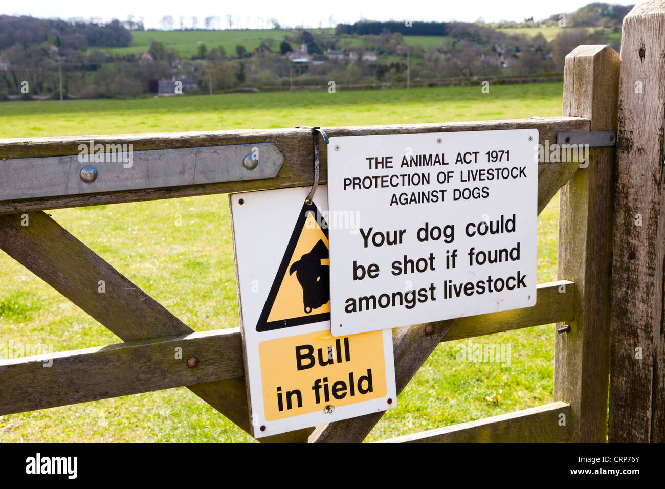 Warning notices on a gate to a field of grazing land crossed by a public footpath at Great Barrington, Gloucestershire Stock Photo