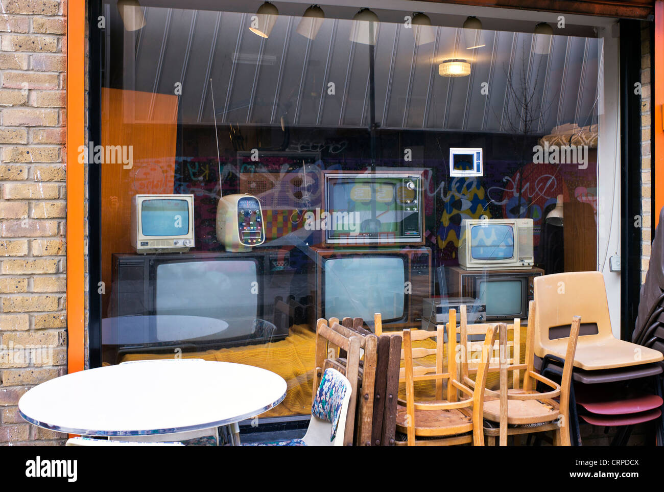Tables and chairs outside Speedies Retro TV and furniture store in Shoreditch in the East End of London. Stock Photo
