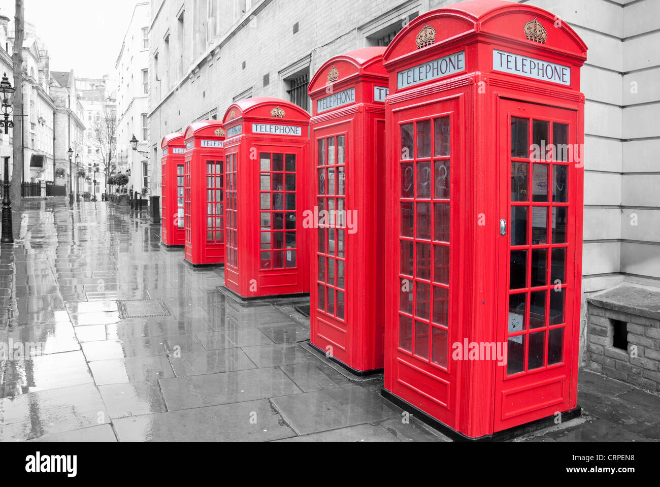 Row of telephone boxes in London on a rainy day Stock Photo