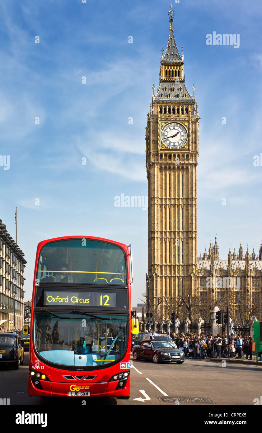 A red London Bus opposite Big Ben, one of the most iconic landmarks in London. Stock Photo