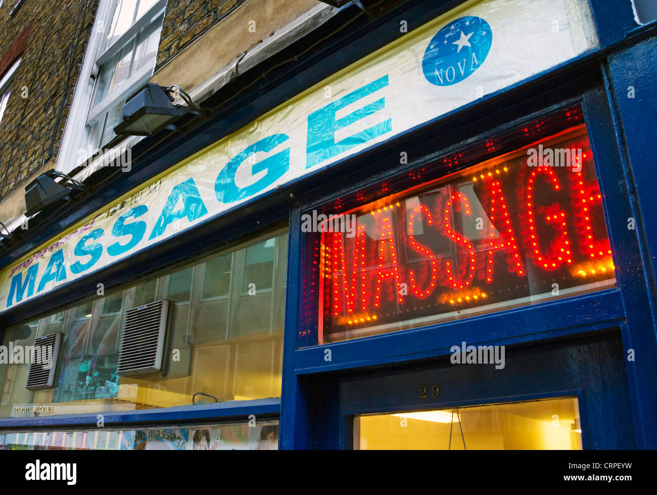 Neon sign above the entrance to a massage parlour in Whitcomb Street, near Trafalgar Square. Stock Photo