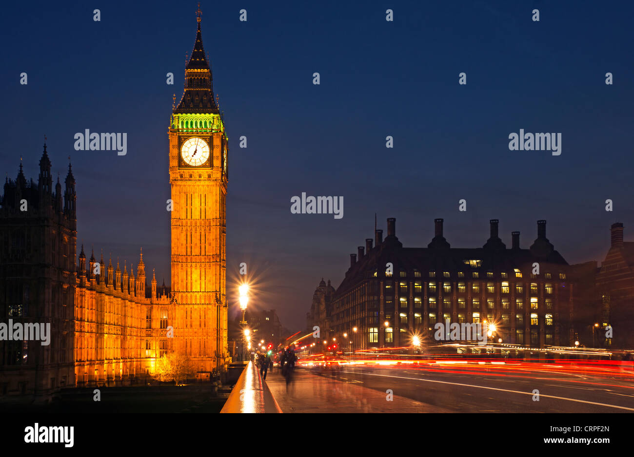 Light trails from traffic travelling across Westminster Bridge by Big Ben and the Houses of Parliament. Stock Photo