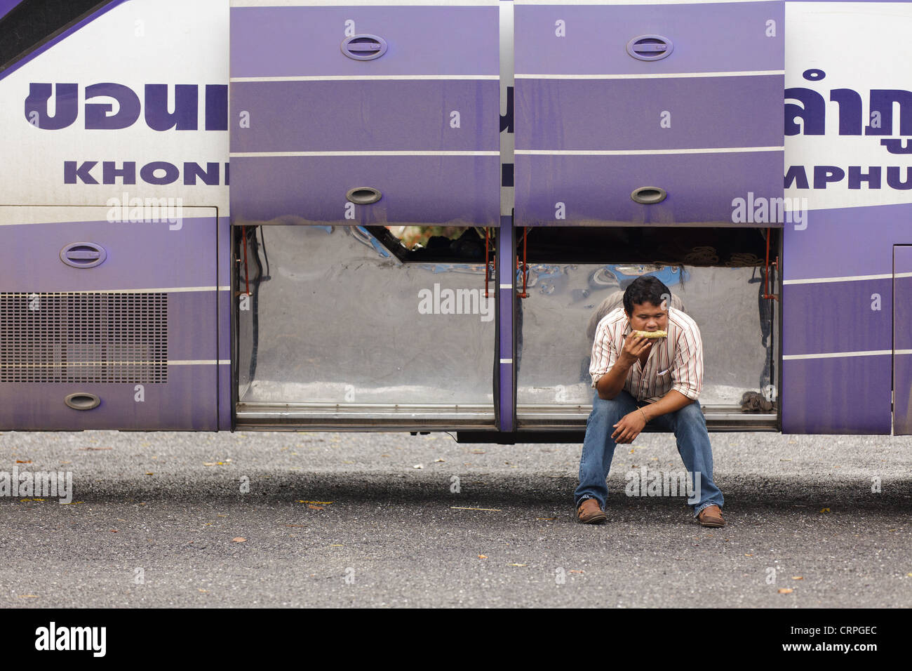 Man eating, sit in bus baggage boot, thailand Stock Photo - Alamy