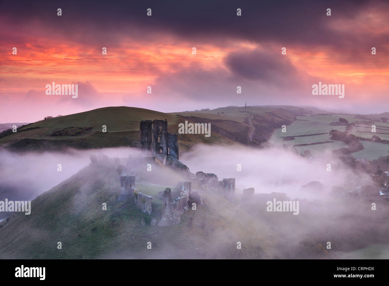 The ruins of Corfe Castle rising through the morning mist. Stock Photo