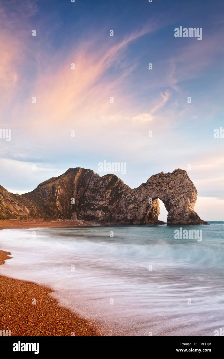 Durdle Door, a natural Limestone arch near Lulworth Cove, part of the UNESCO Jurassic Coast at sunset. Stock Photo