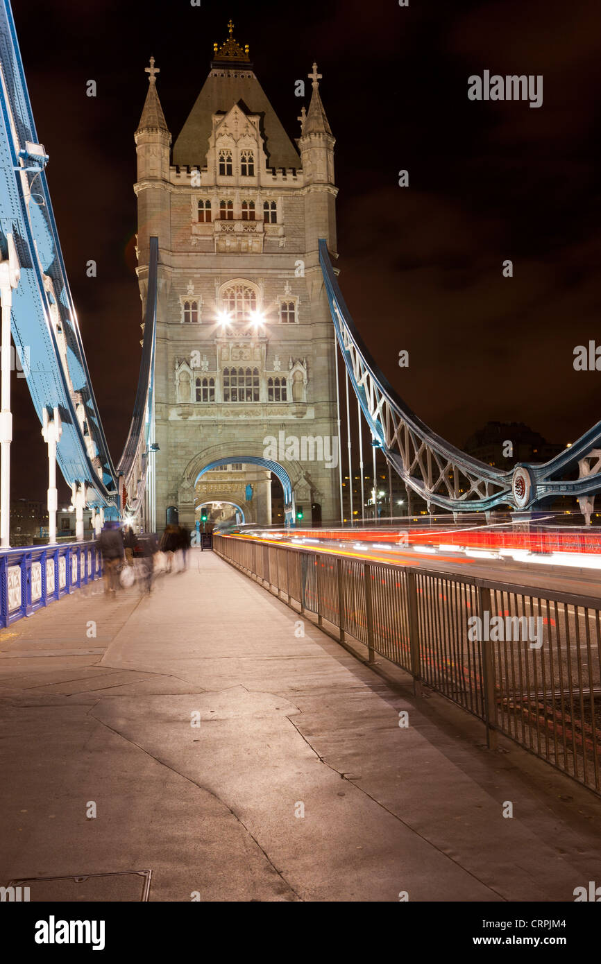 People and traffic crossing Tower Bridge at night. Stock Photo