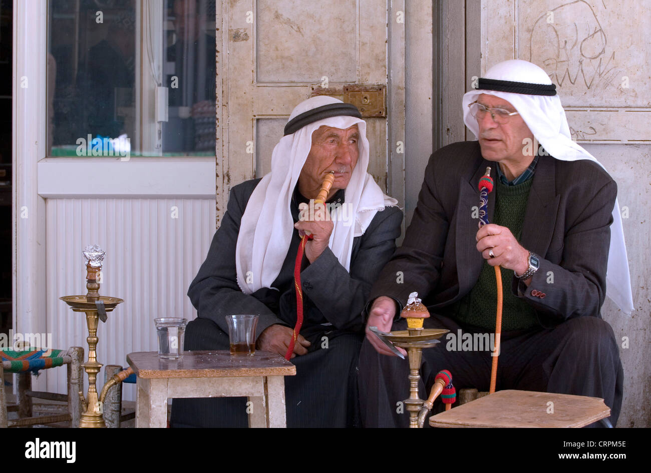 Arab men smoke sheesha pipes in the Old City's Muslim Quarter, Jerusalem, Israel Stock Photo
