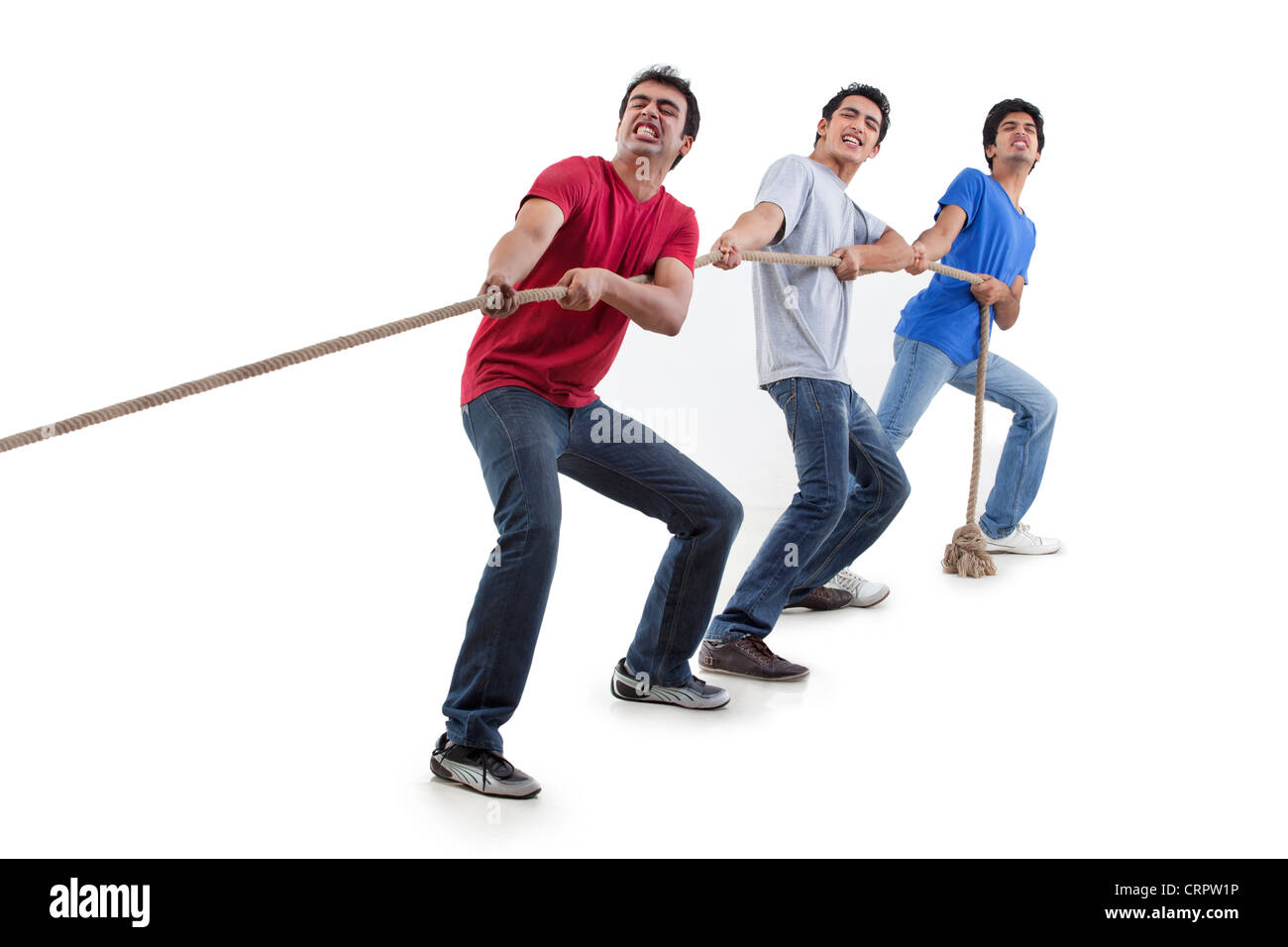 Friends pulling rope together over white background Stock Photo Alamy