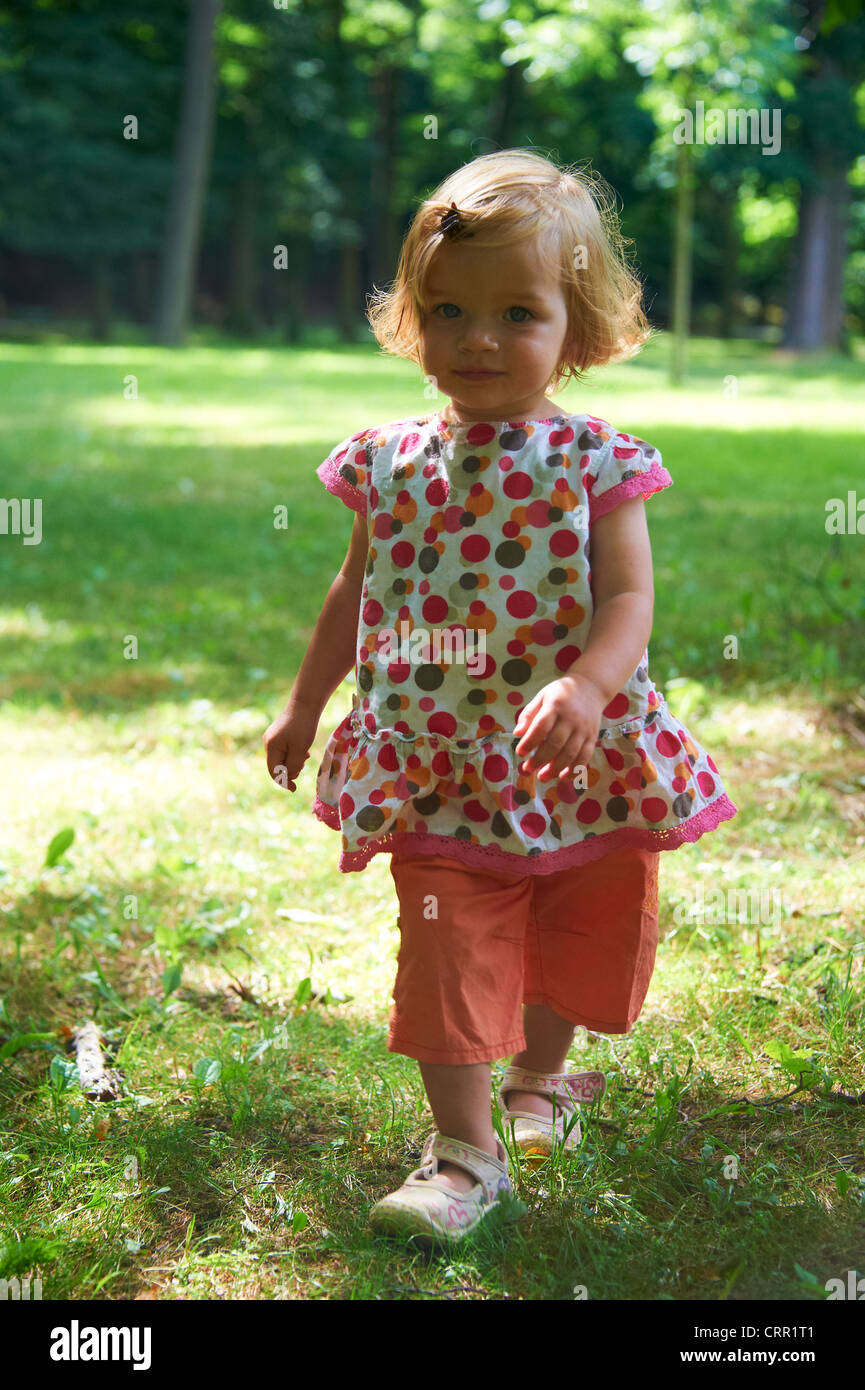 Cute little blond child baby girl walking in park Stock Photo - Alamy