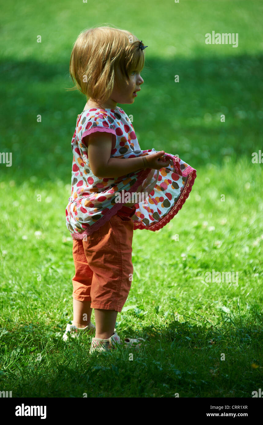 Cute little blond child baby girl walking in park Stock Photo - Alamy