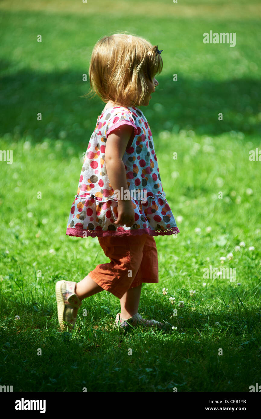 Cute little blond child baby girl walking in park Stock Photo - Alamy