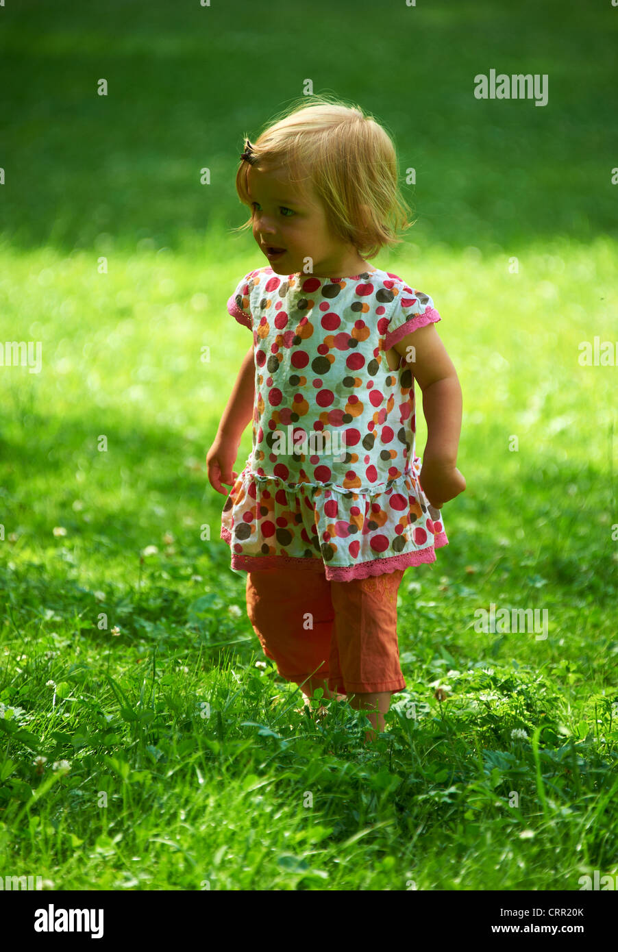 Cute little blond child baby girl walking in park Stock Photo - Alamy