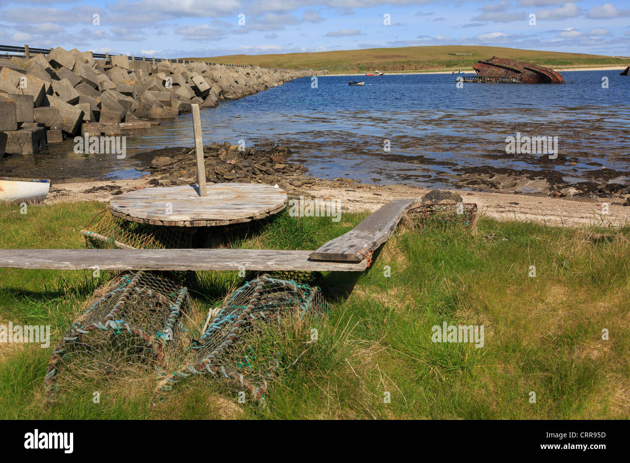 View across Weddell Sound to Glimps Holm Island with Churchill barrier causeway and sunken block-ship Orkney Islands Scotland UK Stock Photo