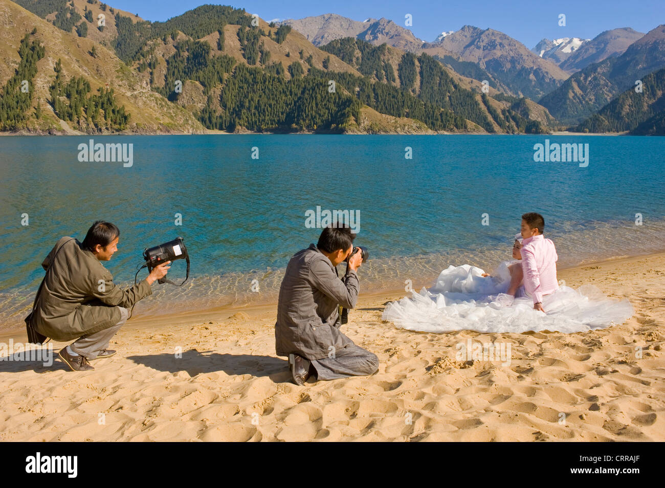 A Chinese couple pose for their wedding photographs at the popular alpine beauty spot of Heavenly Lake. Stock Photo
