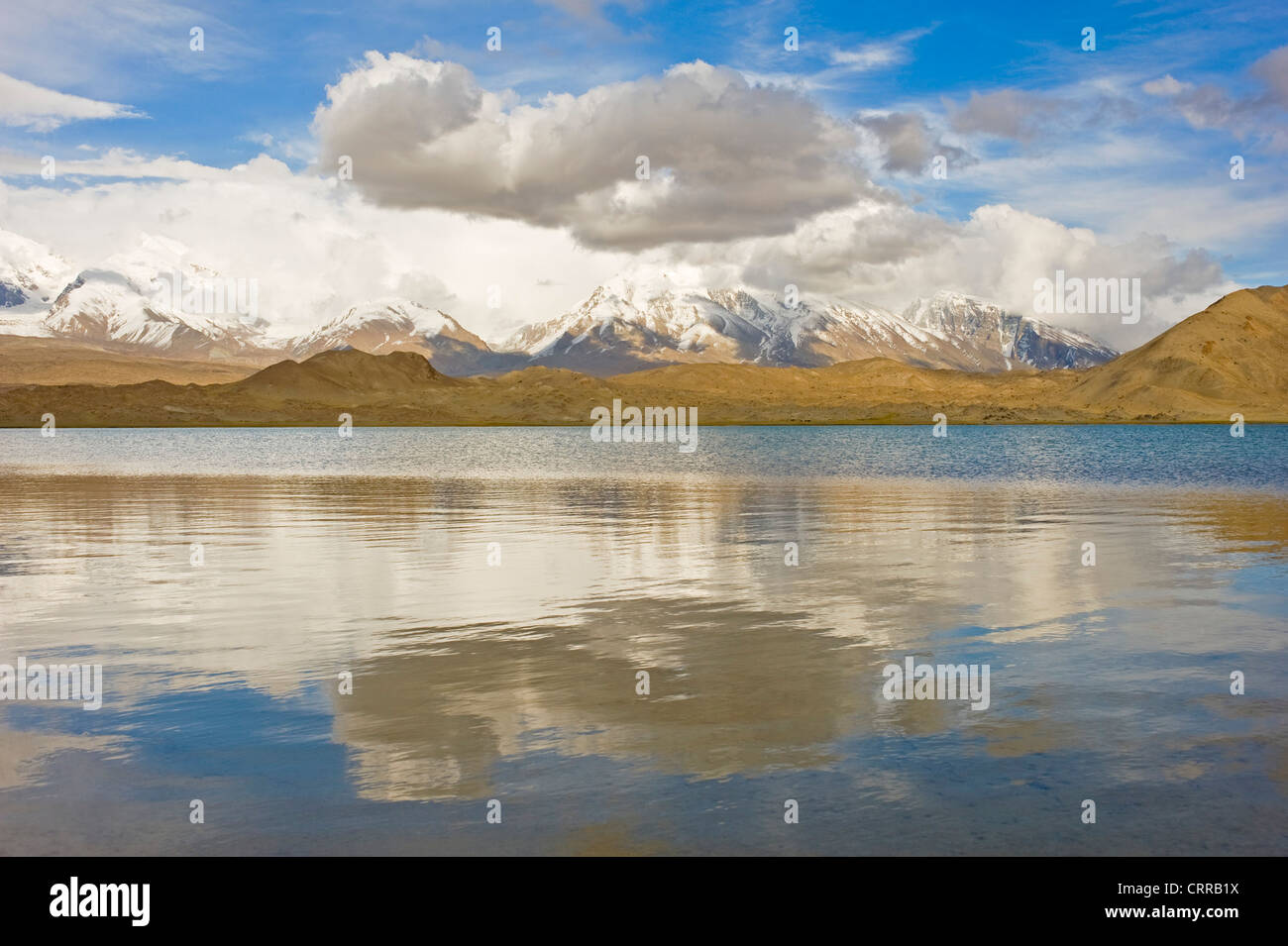 A landscape view of Lake Karakul or Karakuli ('black lake') with the Kunlun mountain range in the background. Stock Photo