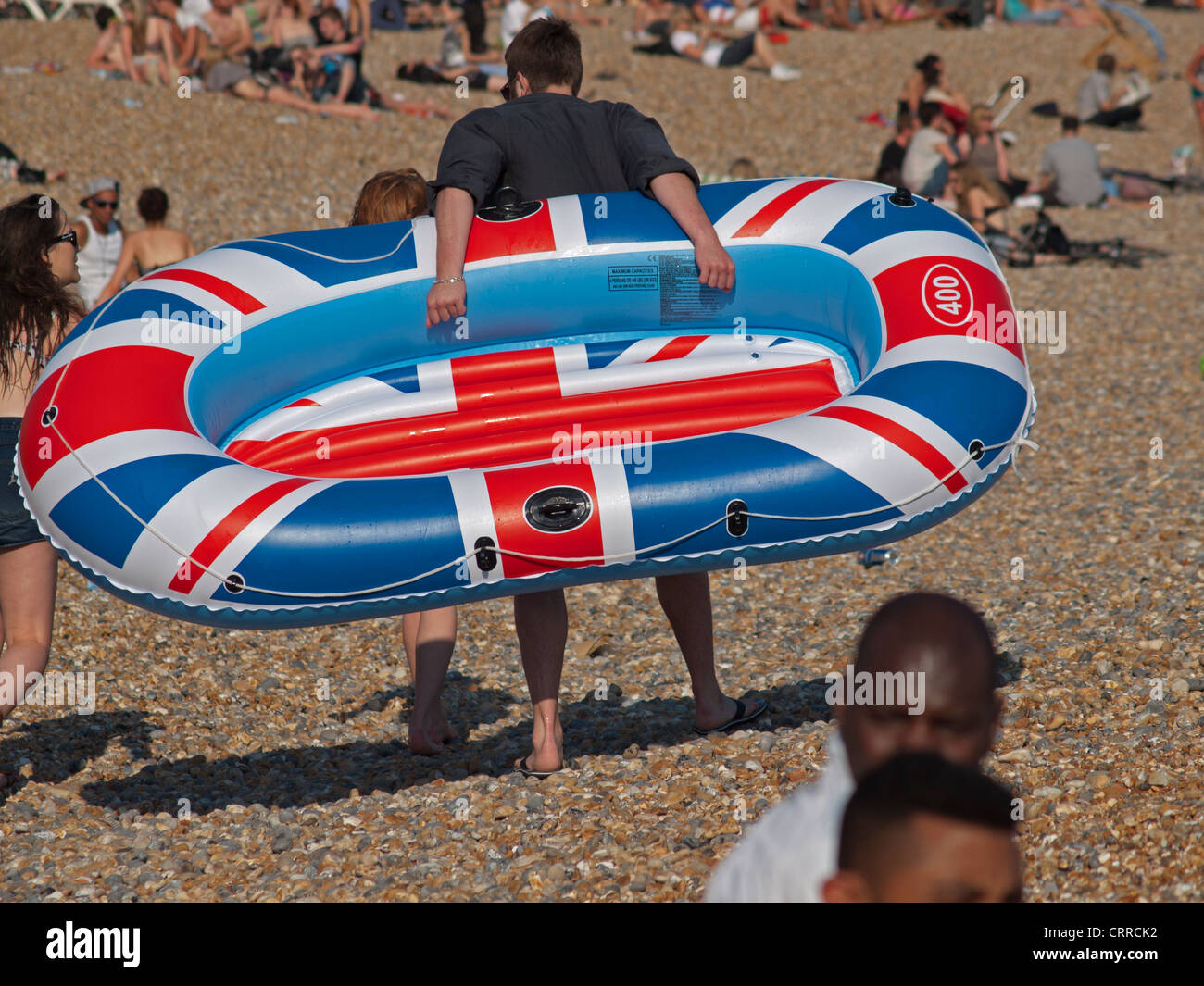 An inflatable boat is carried across Brighton beach Stock Photo - Alamy