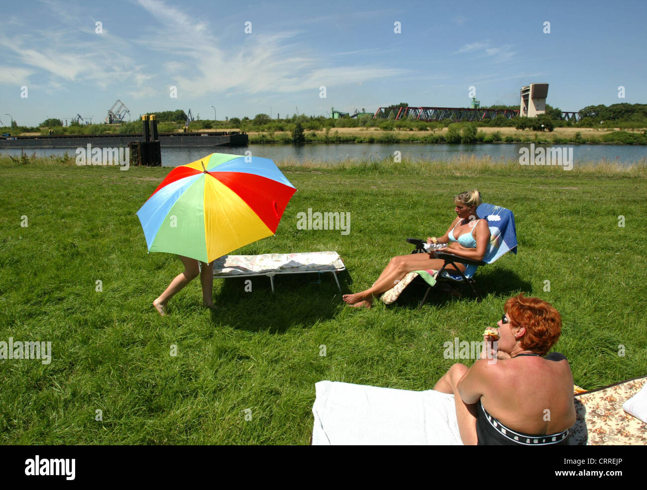 Family lying in the sun on the Ruhr in Duisburg Stock Photo