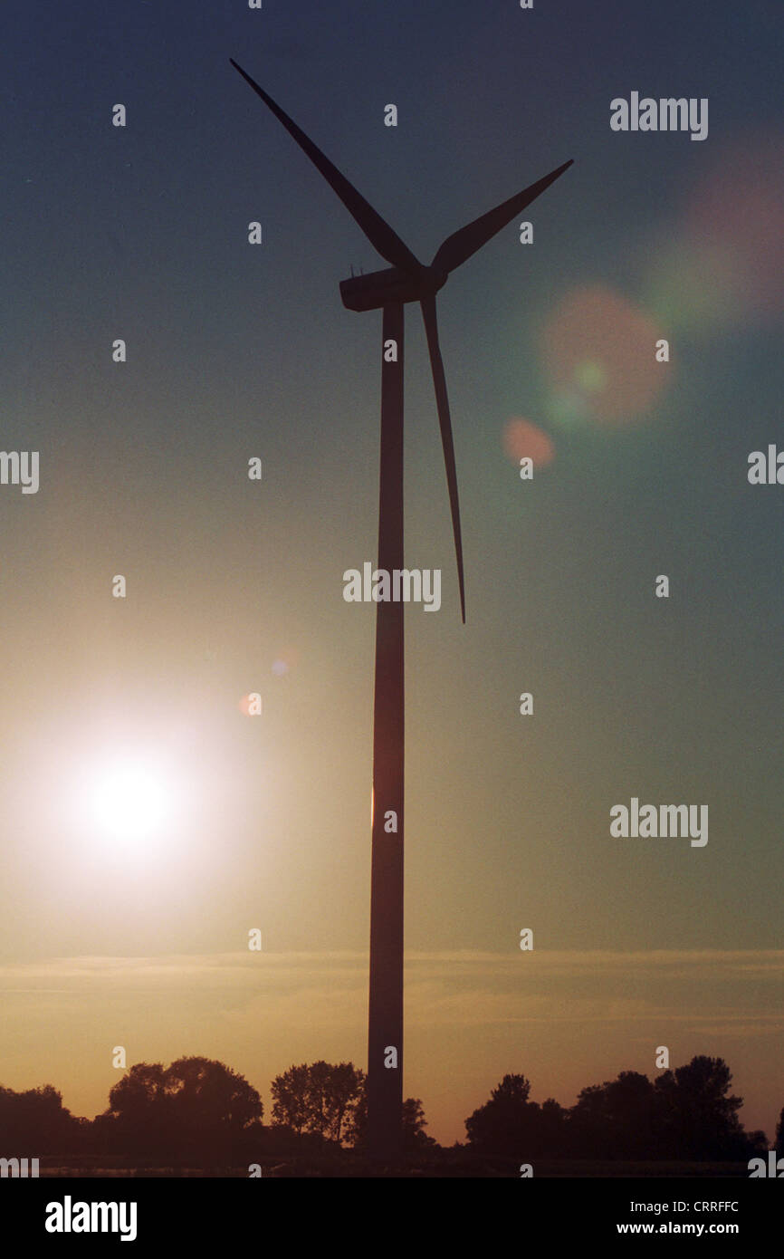 A wind turbine in front of the setting sun Stock Photo