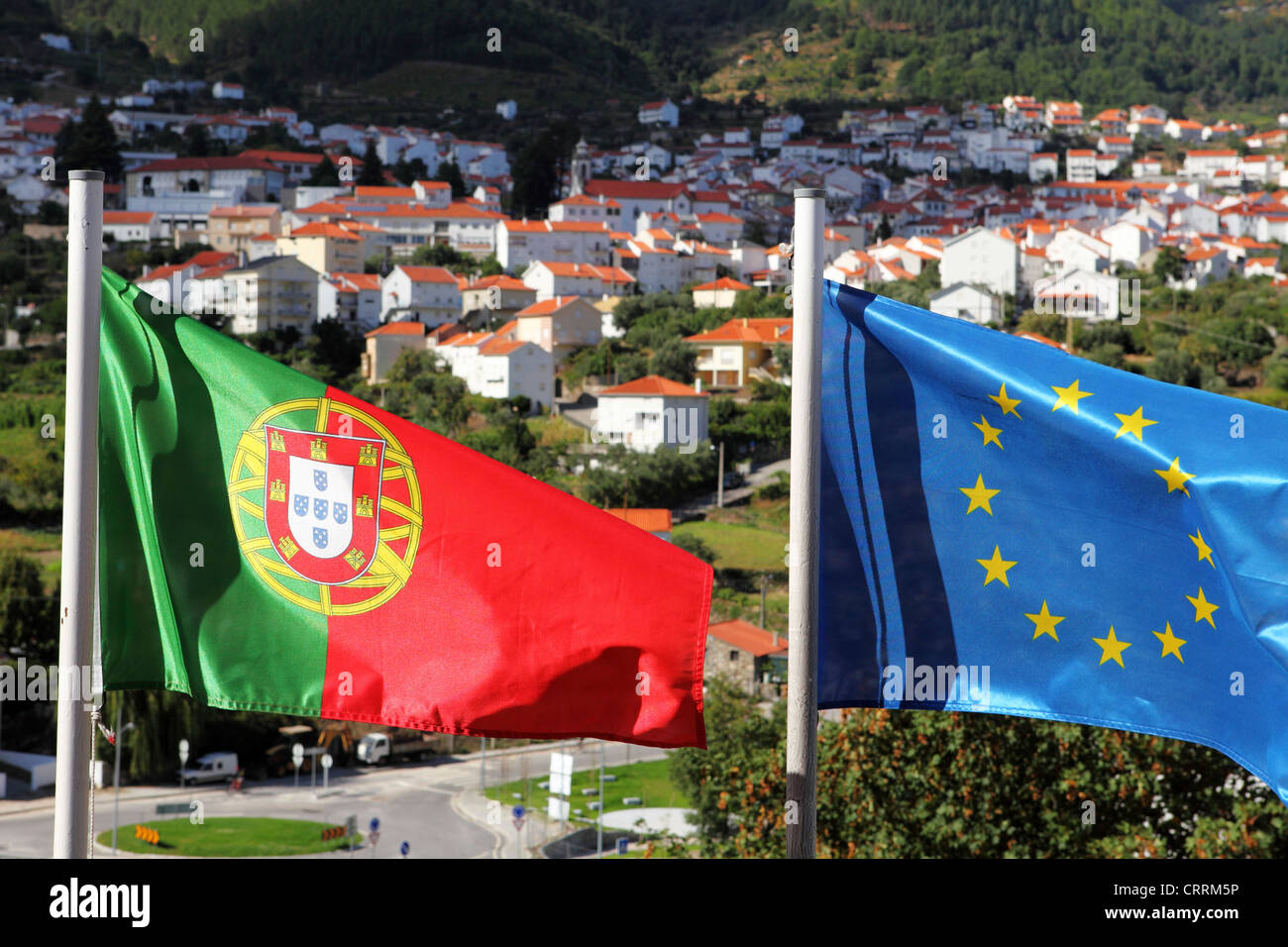 The Portuguese and European flags flutter side by side from flagpoles in Manteigas, Portugal. Stock Photo