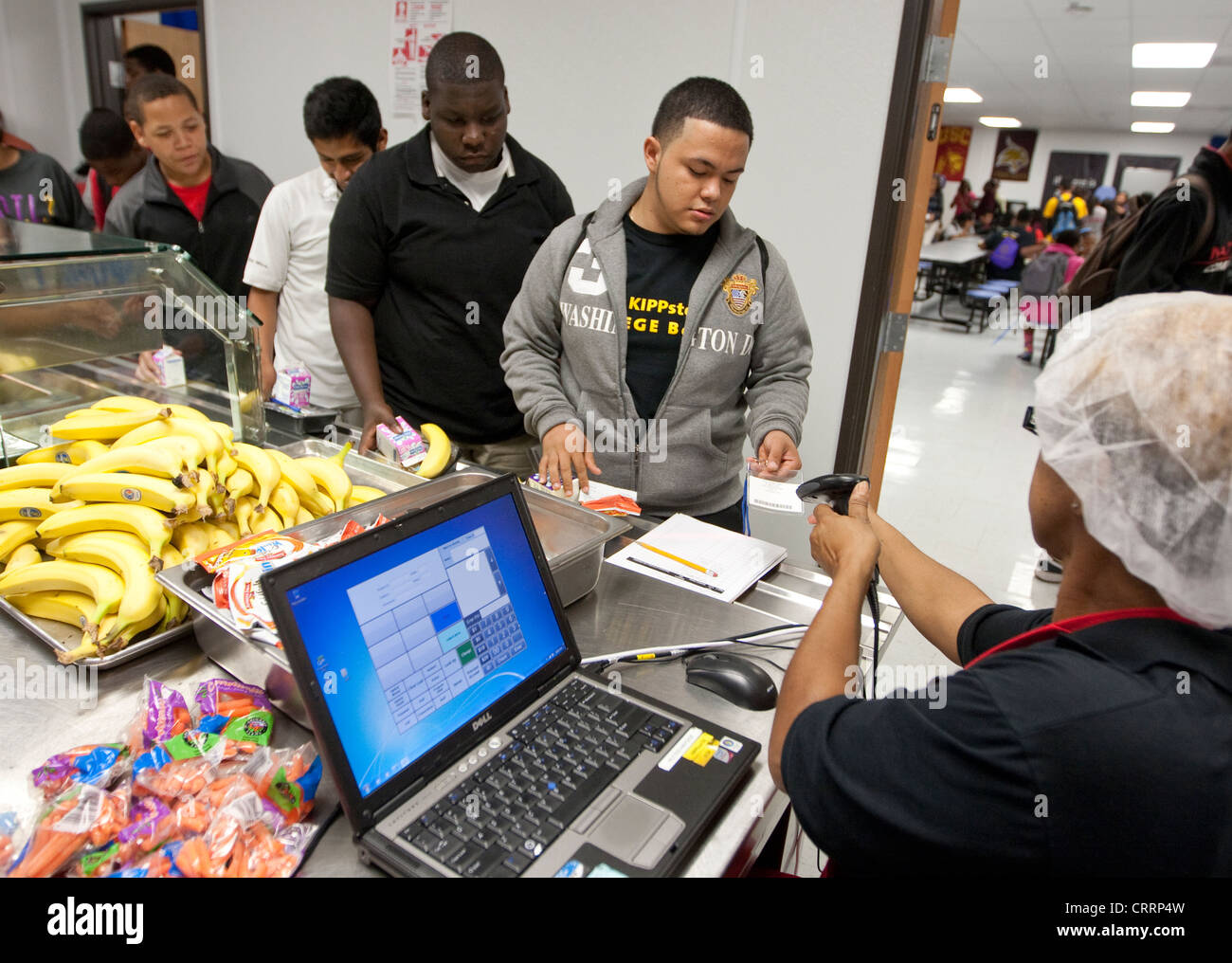Cafeteria worker uses handheld scanner to read barcode information on