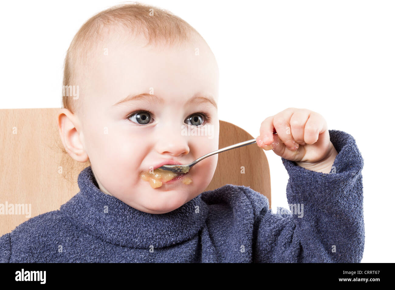 baby eating applesauce studio shot isolated on white background Stock