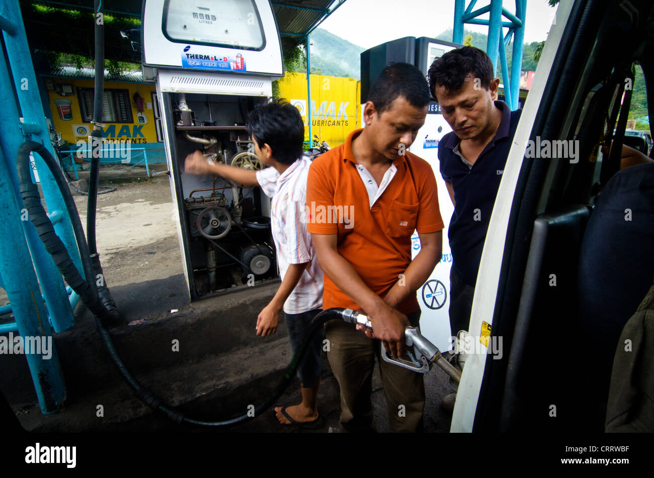 A pumps gasoline on a hand crank benzine pump in Nepal Stock Photo