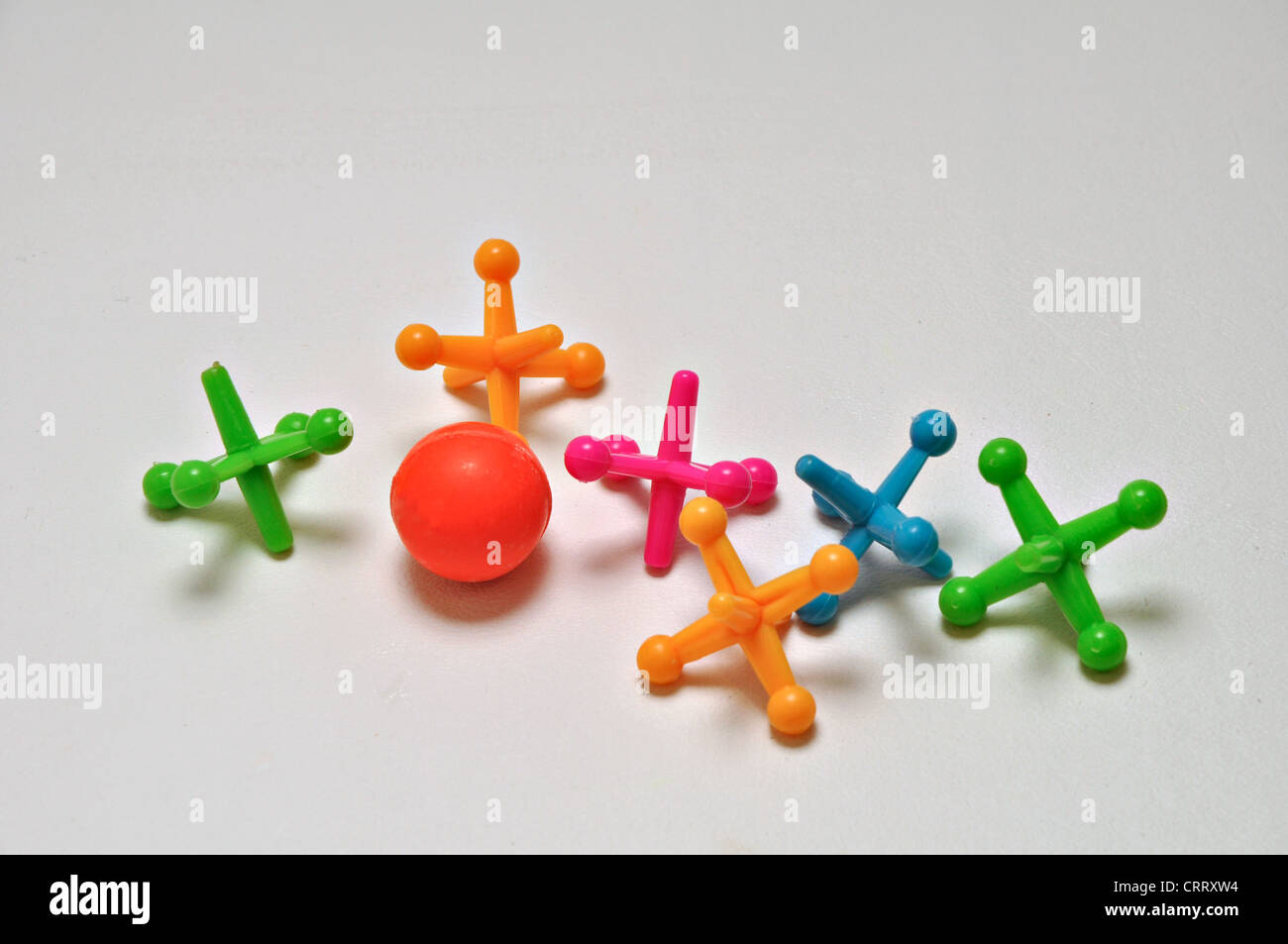 A set of ball and jacks rest on a plain background Stock Photo