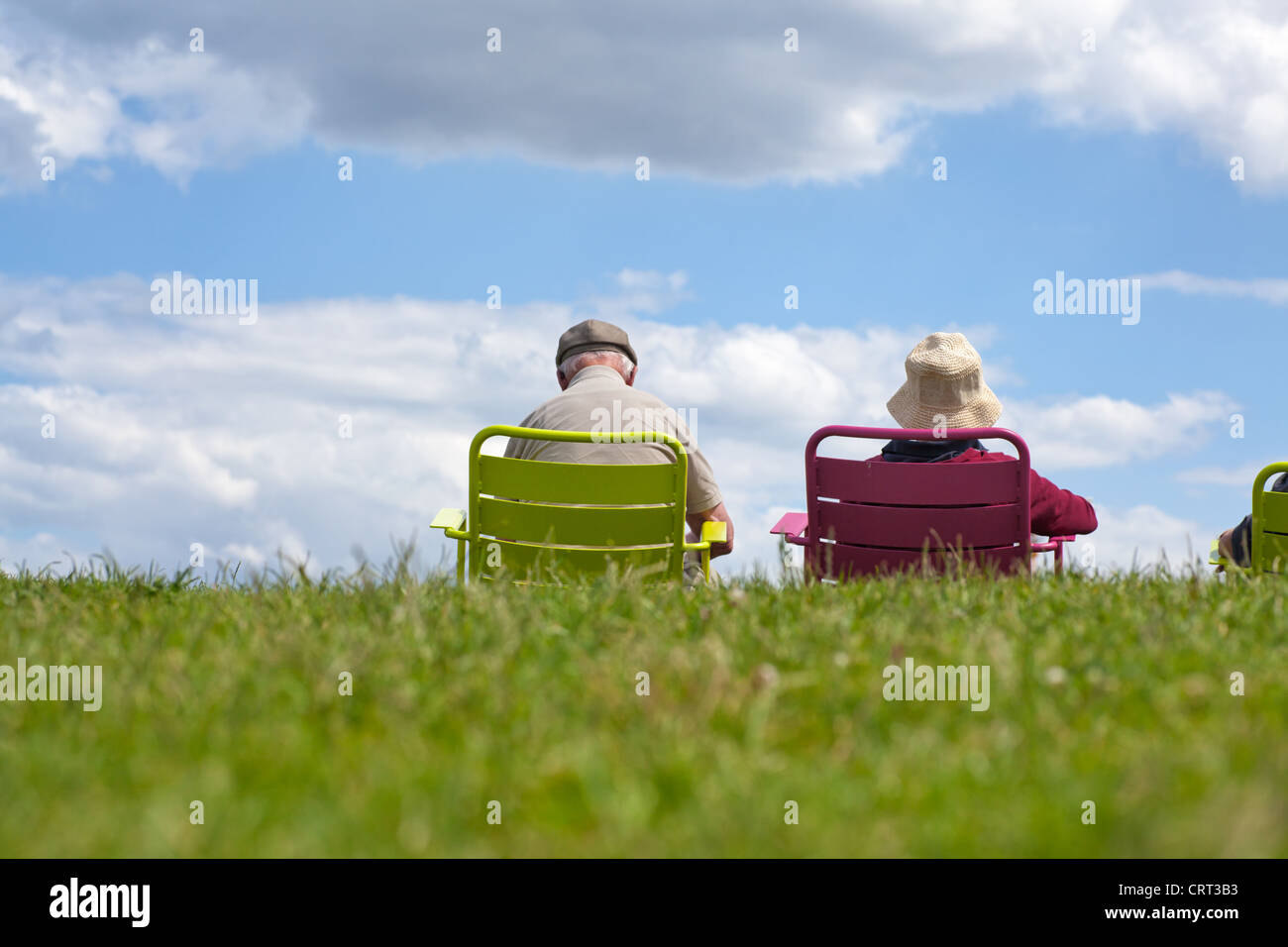 Senior couple enjoying retirement - relaxing in the park against a clear blue sky. Stock Photo