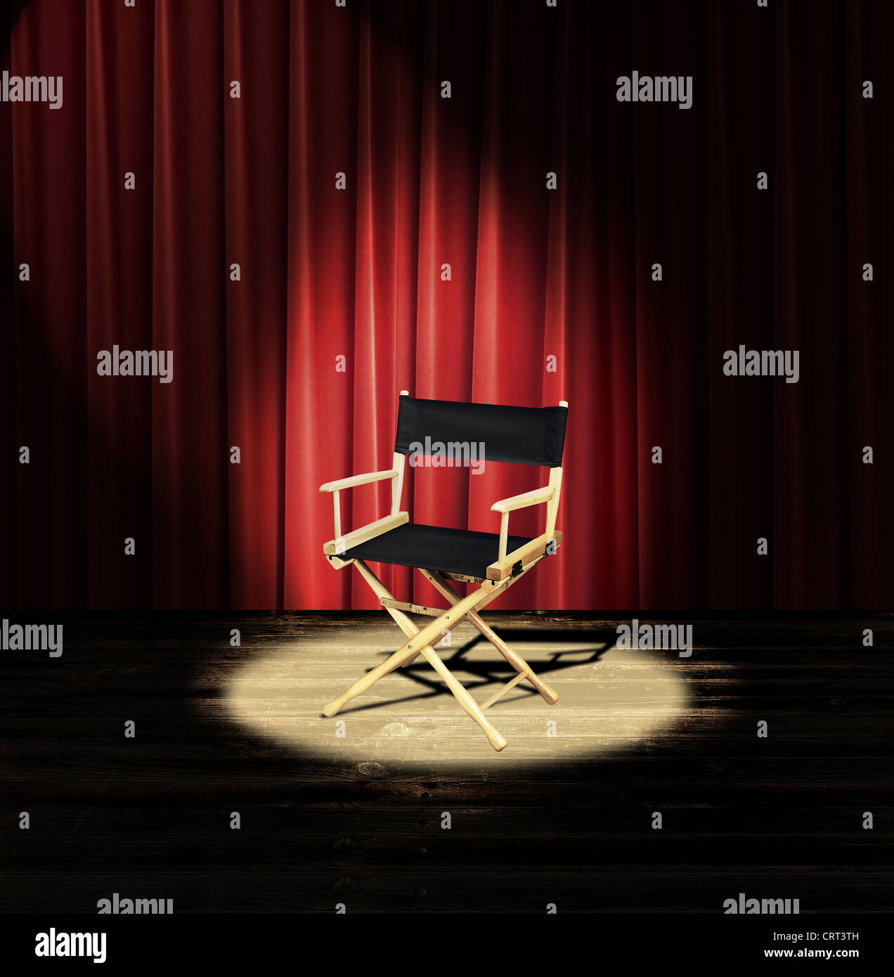 A directors chair on a stage with a red curtain and spotlight Stock