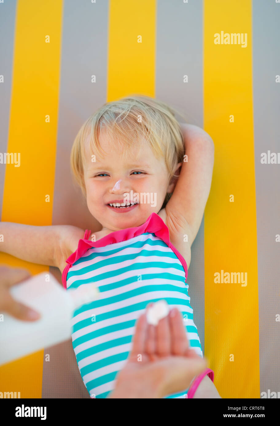 Baby waiting while mother applying sun block creme Stock Photo Alamy
