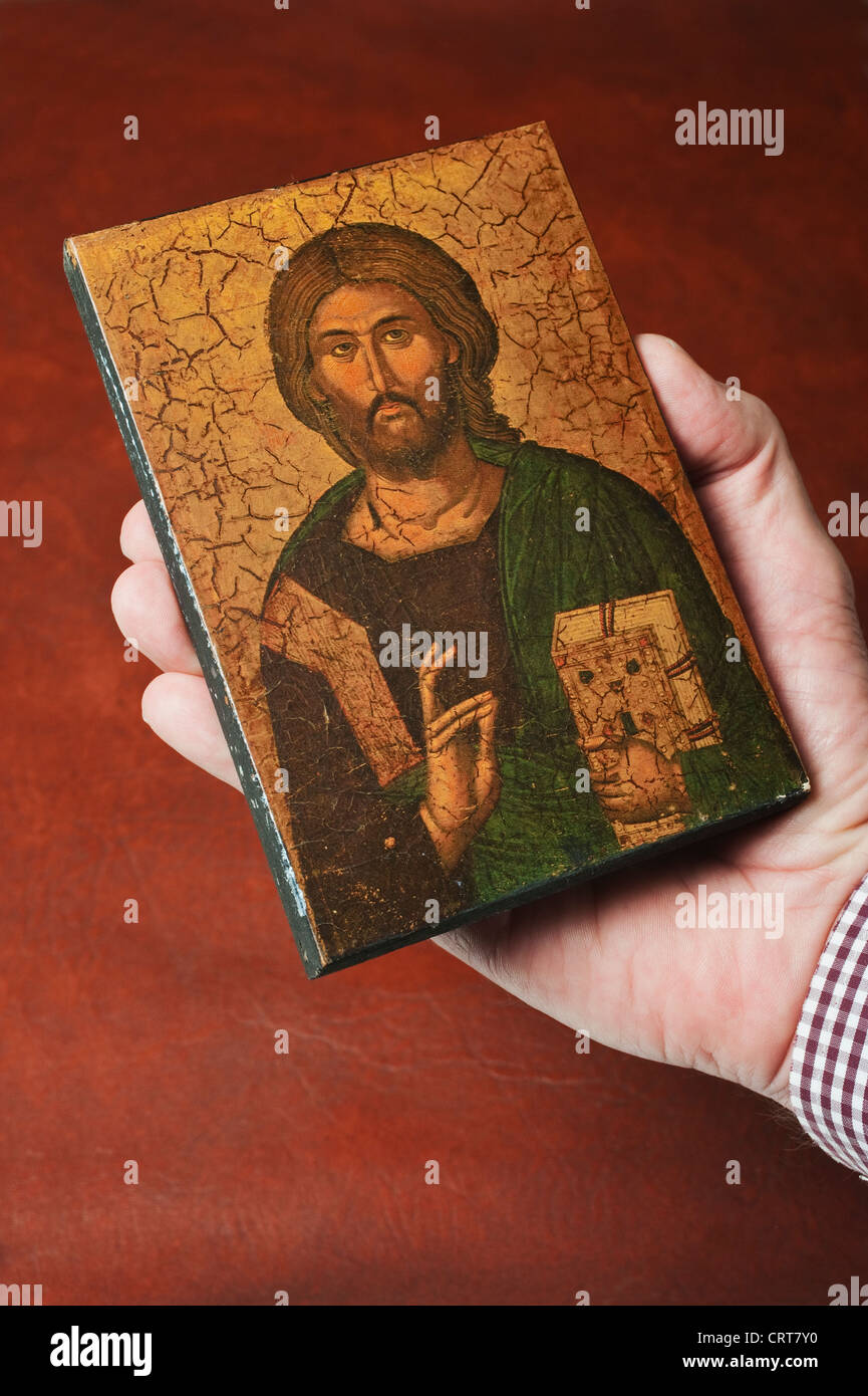 A small Russian religious icon held in a male hand Stock Photo
