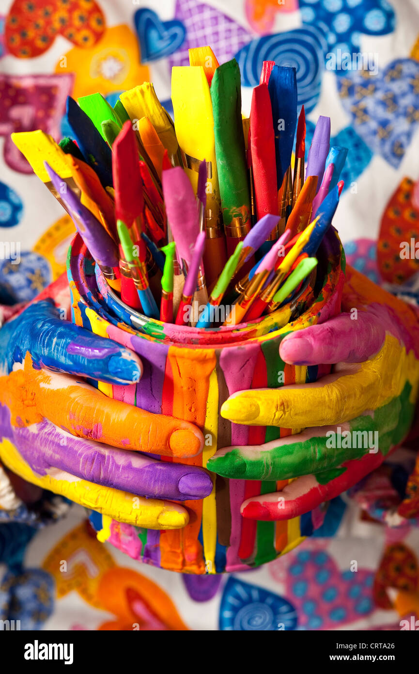 Close-up of woman holding multicolored paint can with painted fingers Stock Photo