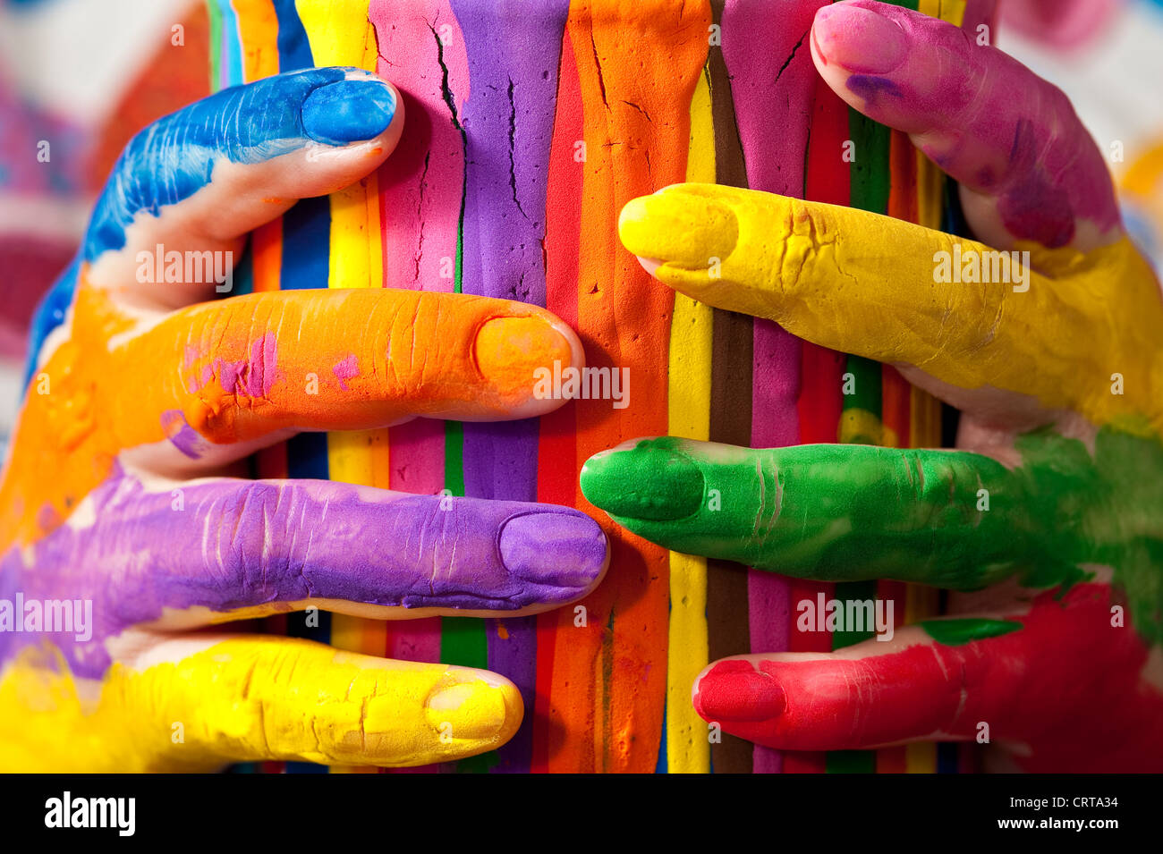 Close-up of woman holding multicolored paint can with painted fingers Stock Photo