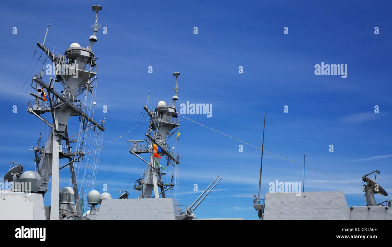 Upper Profile of part of the deck of a Navy Cutter with radar and guns against blue sky Stock Photo