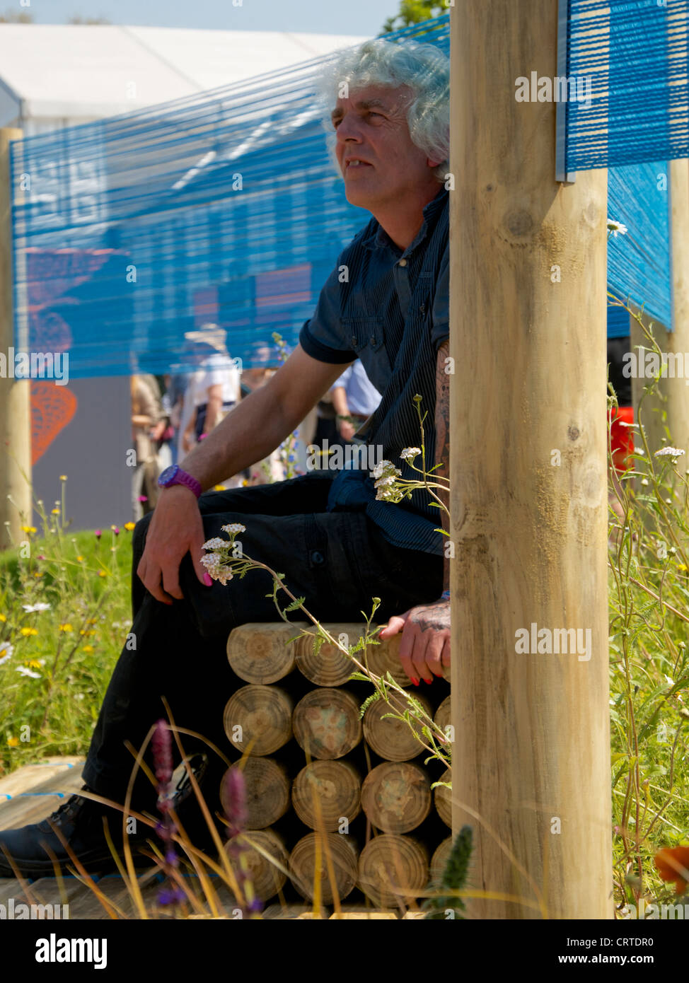 Designer Alan Gardner sitting in his Out of the Blue Garden at RHS Chelsea Flower Show 2012 Stock Photo