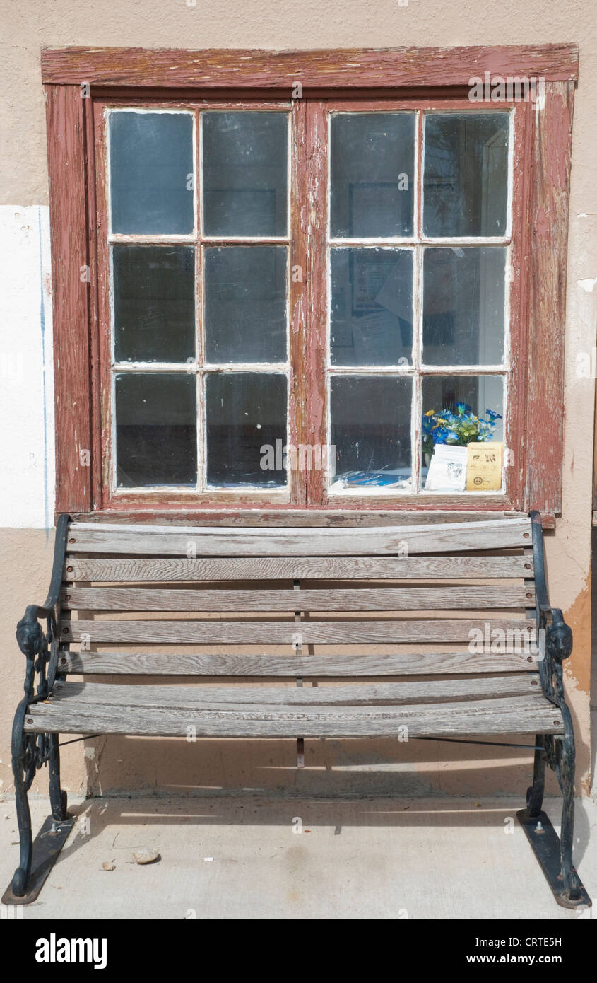 An old wooden bench sits on the side of the Fort Stanton Post Office