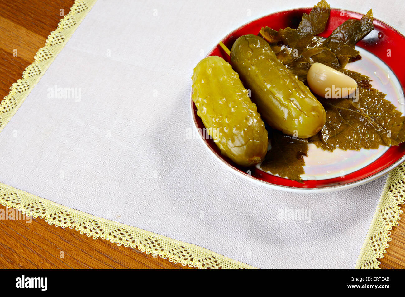 Marinated cucumbers on plate with garlic and currant leaf Stock Photo