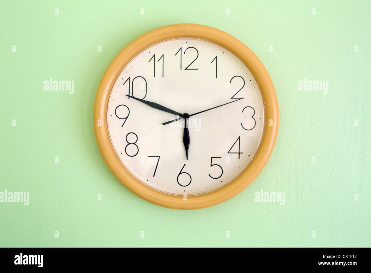 Clock hanging on wall and showing current time stock photo alamy