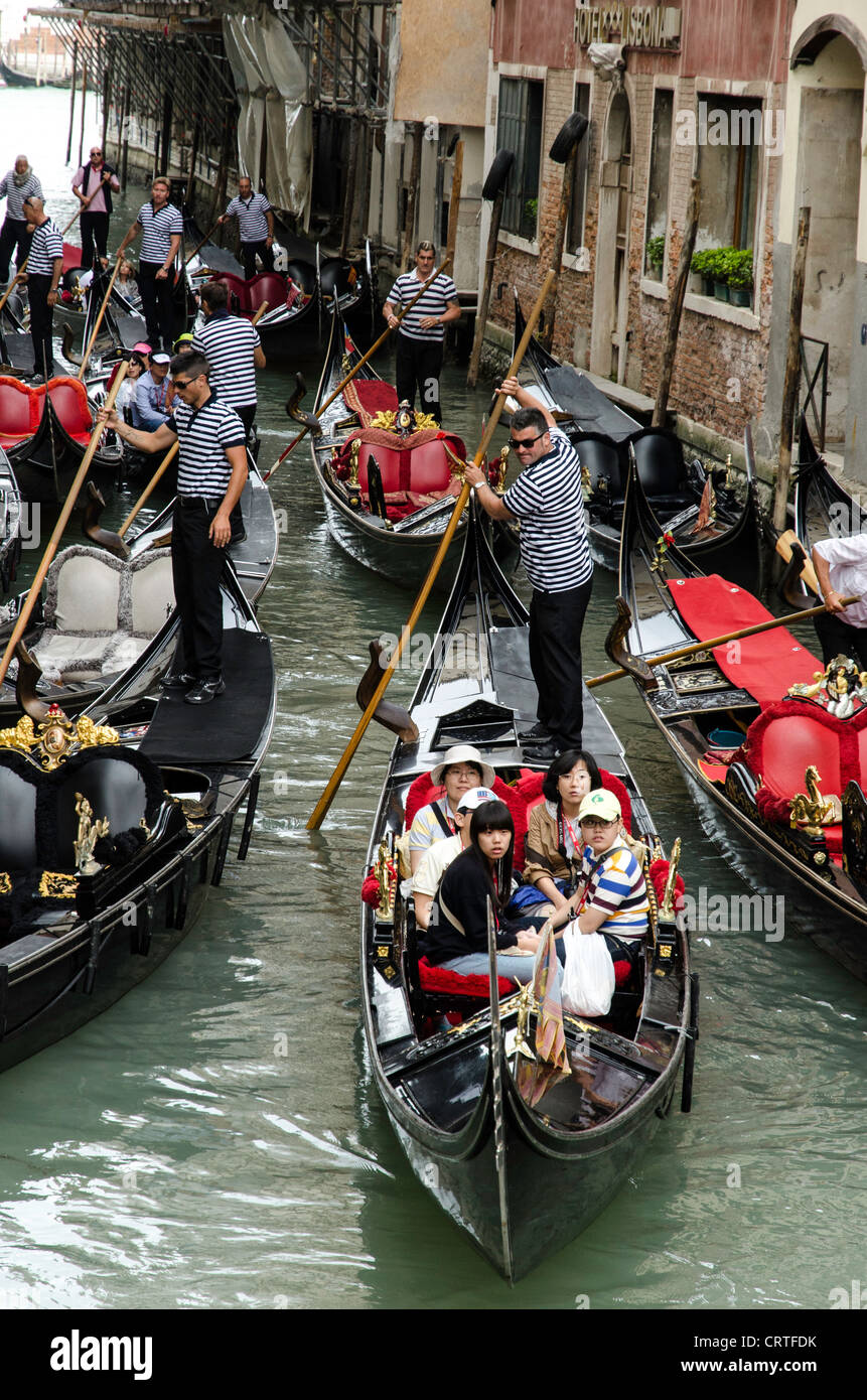 Gondoliers and Chinese tourists on a gondola Venice (Venezia)