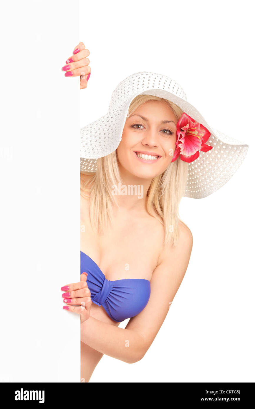 An attractive blond woman in swimsuit holding a white panel isolated on white background Stock Photo